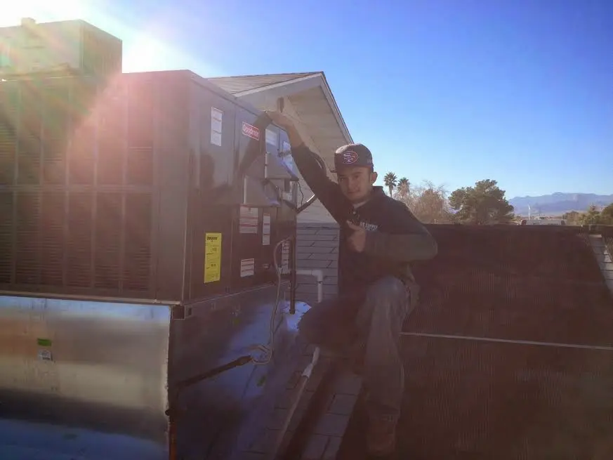 HVAC technician performing AC Tune-Up on a rooftop unit in Forestbrook